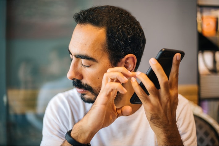 Blind man speaking into his mobile phone