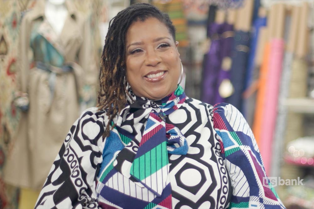 Woman smiling at the camera wearing a colorful blouse