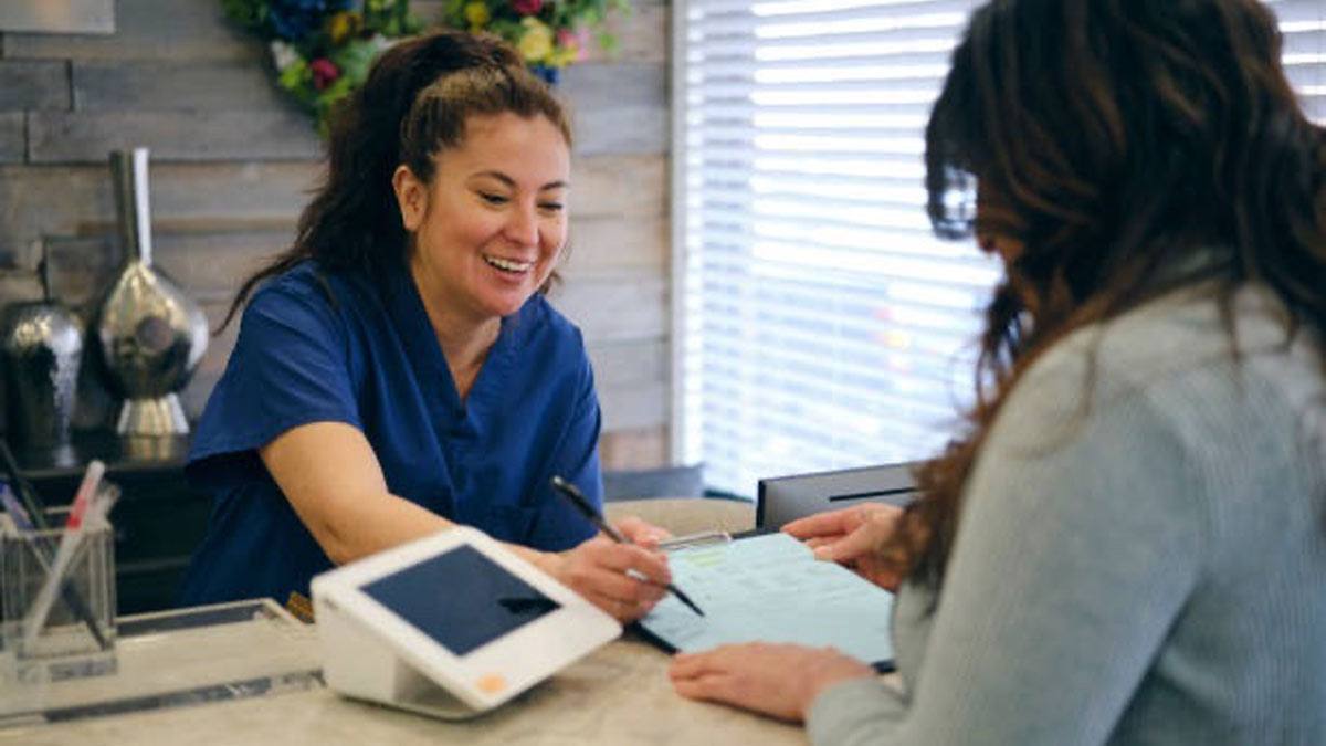 Two people in a medical office discussing a payment