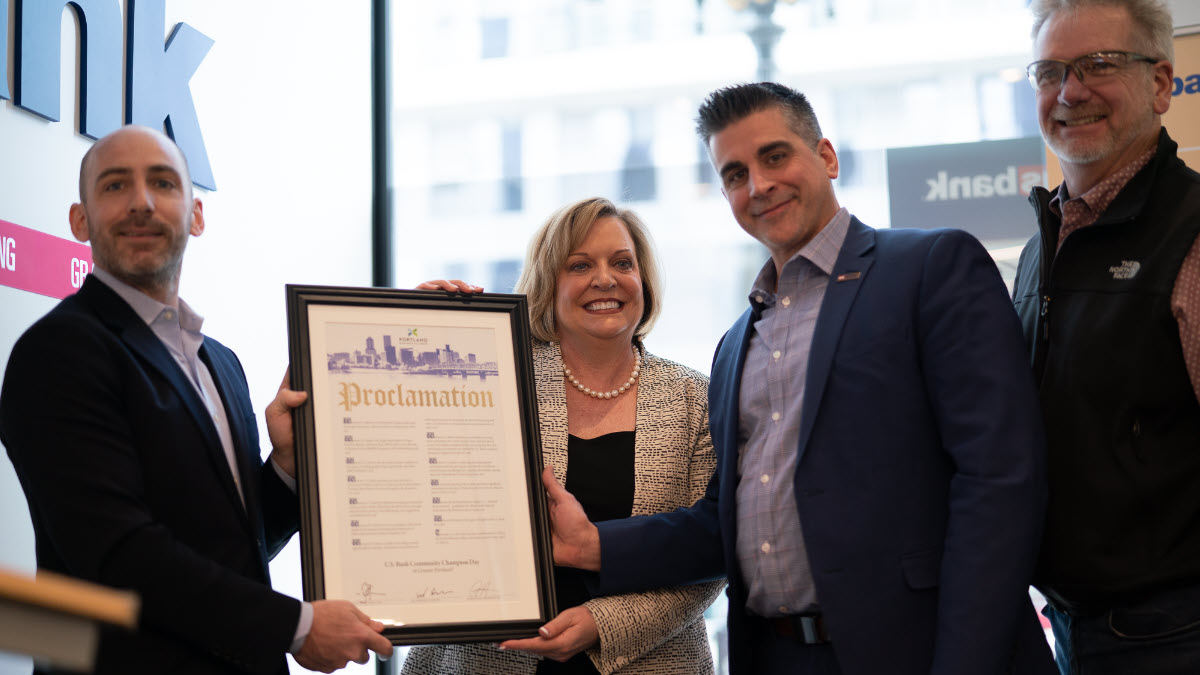 Group of people around a framed certificate