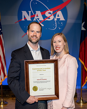 man holding framed award with woman