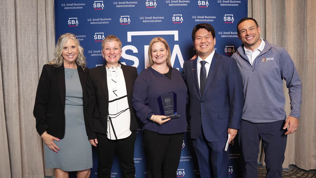 Large group of people holding an award