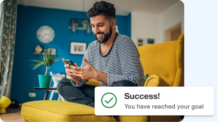 Man reading goal-achieved notification on a mobile phone.