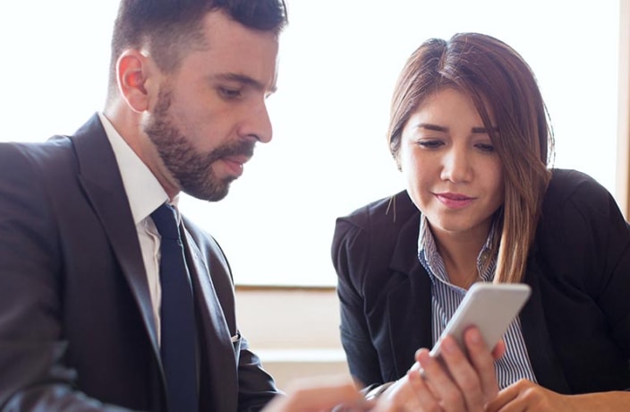 Banker and business client looking at a smartphone 