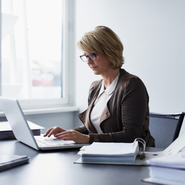 A person typing on their laptop in an office