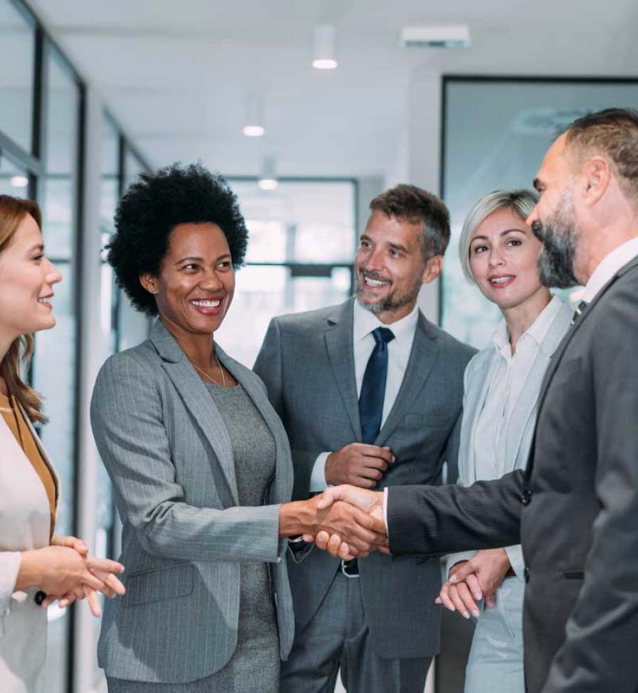 Group of corporate colleagues greeting each other in an office