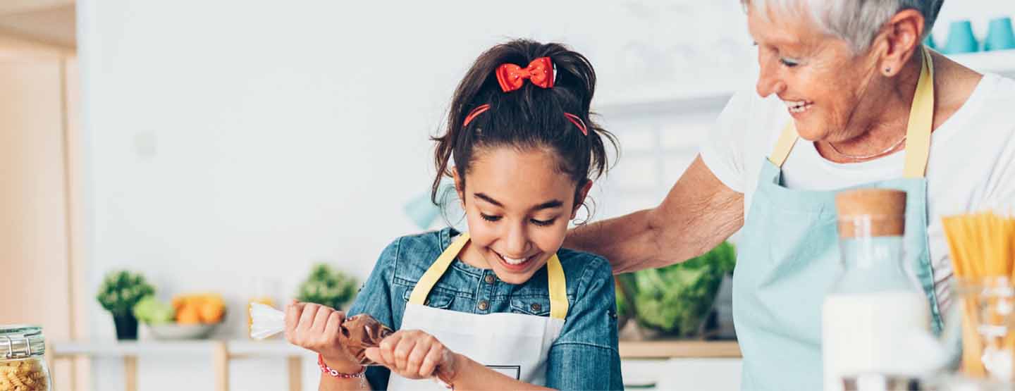 Grandmother baking with granddaughter after reviewing a home-buying guide