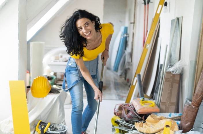 Woman cleaning up in an attic space