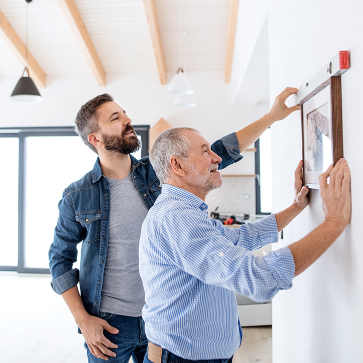 Father and son hanging a picture