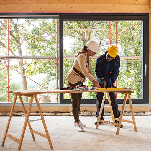 Woman and man looking at plans inside a half built home