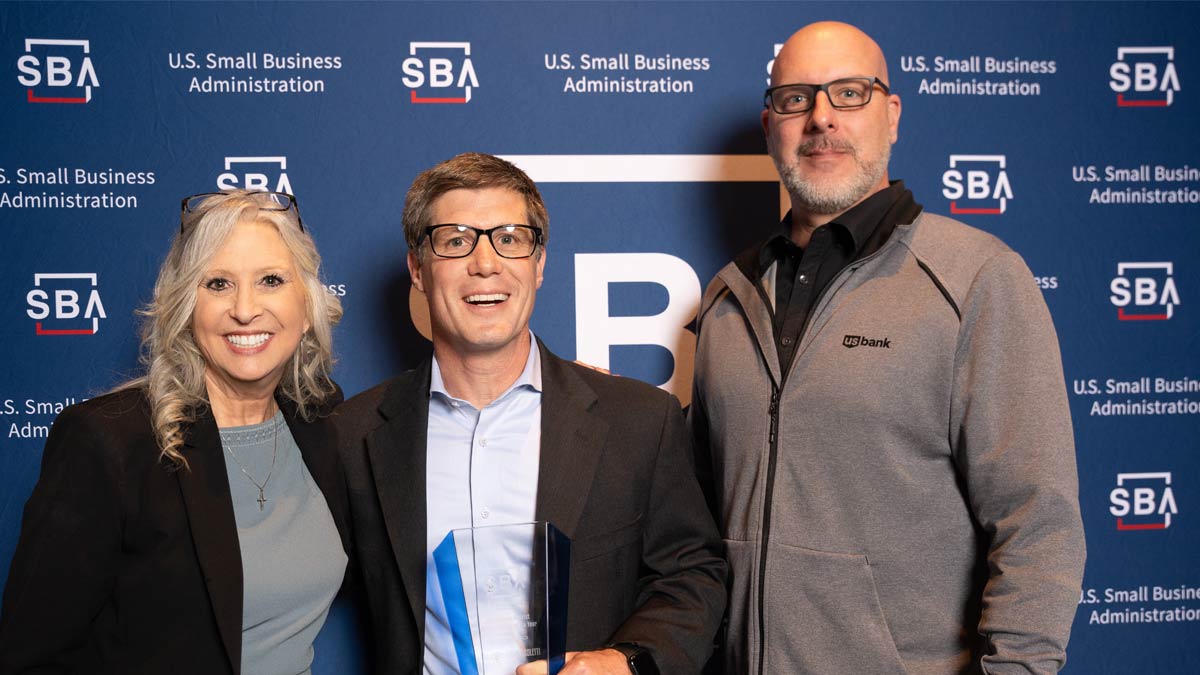 three people holding an award