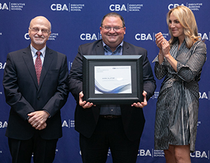 photo of three people on award stage