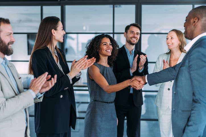 Image of colleagues clapping and congratulating women.