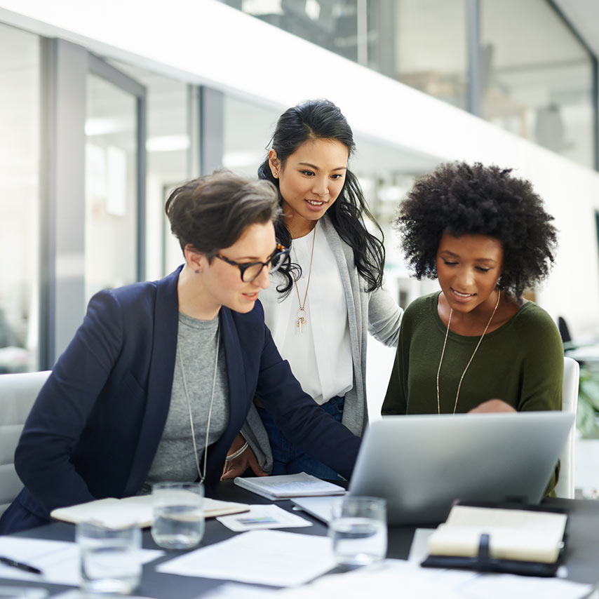 Three professional women in a meeting in an office.