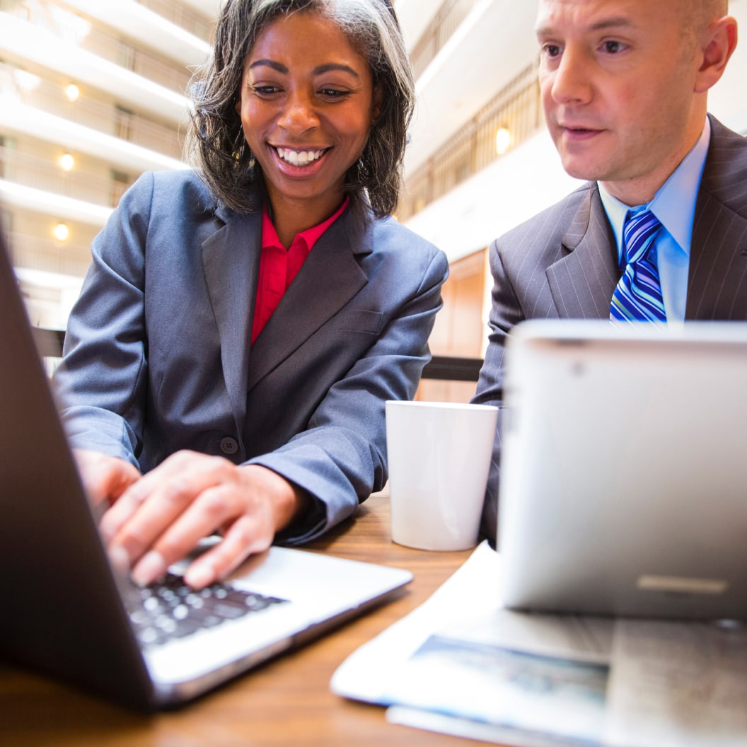 Man and woman in suit sharing tech