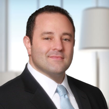 Headshot of Josh Jacobs wearing a suit and tie