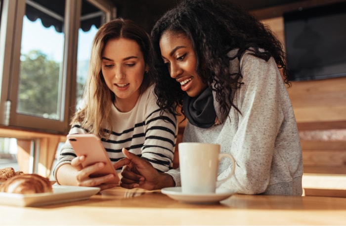 Amigos utilizando un teléfono inteligente juntos