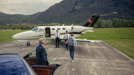 Chauffeur dropping off client in front of private airplane